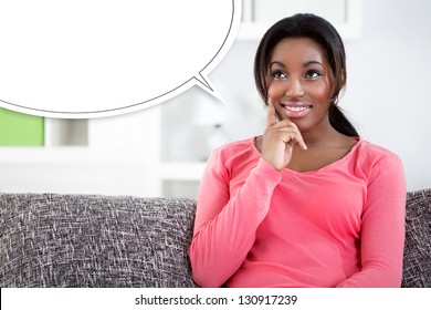 Black Woman Sitting On Sofa And Dreaming About Something,  Blank Balloon At The Top Of The Photo