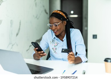 Black Woman With Smart Phone And Credit Card Purchasing Grocery Delivery From Internet In Kitchen