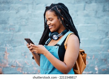 Black woman, smile and phone of a student from Jamaica with technology and headphones. Happy, urban and gen z person using 5g internet, web and social media app scroll while texting with happiness - Shutterstock ID 2211548817