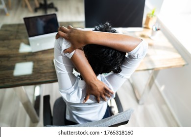 Black Woman Stretches In Office At Desk