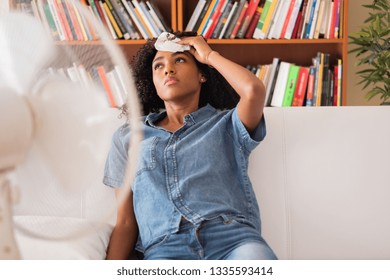 Black woman sweating and trying to refresh at home