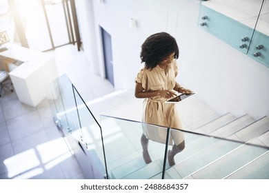 Black woman, tablet and walking on stairs for communication, networking and check schedule. Female person, technology and steps with social media, conversation and online meeting calendar for work - Powered by Shutterstock