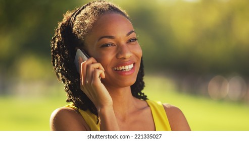 Black Woman Talking On Phone Outdoors