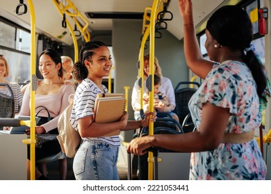 A black woman is talking to a young student on the city bus