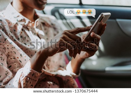 Black woman texting in a car