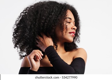 black woman touches her curly hair