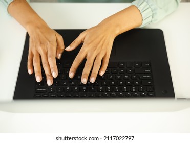 Black Woman Typing On Laptop Computer Keyboard. Freelancer Person Working On Modern Notebook Pc Behind White Office Desk. Entrepreneur Female Doing Distant Work Online During Lockdown