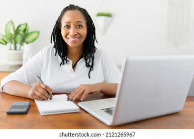 A Black Woman Using Computer In Modern Kitchen Interior