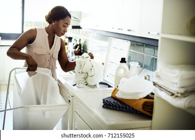 Black Woman Using Washing Machine Doing The Laundry