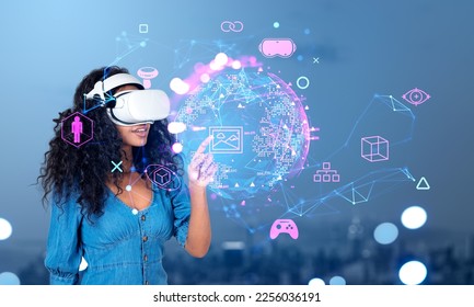 Black woman in vr glasses finger touch earth sphere hologram. Virtual reality icons hologram with cryptoart and games. Concept of metaverse and technology - Shutterstock ID 2256036191