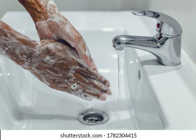 Black Woman Washing Her Hands Rubbing Them Together With The Soap.  Covid-19 Prevention.