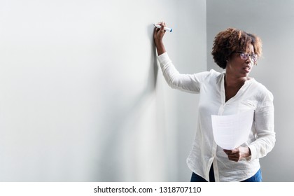 Black woman writing on a whiteboard