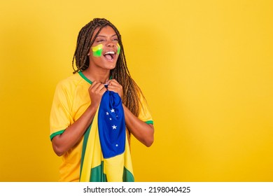 Black Woman Young Brazilian Soccer Fan. Holding Brazil Flag, Anxious, Watching The Match.