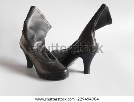 Black woman's boots on a grey background