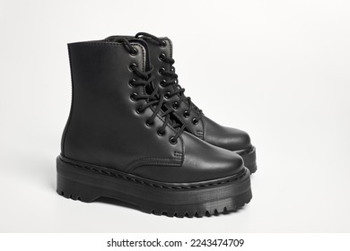 Black women combat boots on high heel platform with lug soles on isolated white background, side view. Military stylish high heel platform combat boots for woman legs, new footwear trends - Powered by Shutterstock