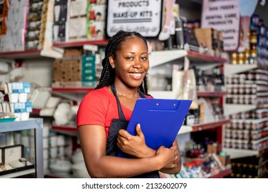 Black Women owning small business posing looking at the camera holding a a clipboard with hand crossed . Business concept