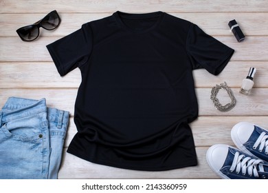 Black Womens Cotton T-shirt Mockup With Blue Jeans, Nail Polish, Necklace, Sneakers And Sunglasses. Design T Shirt Template, Tee Print Presentation Mock Up