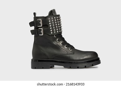 Black women's fashion Combat boot, spring autumn shoe isolated on white background. Female leather luxury casual footwear with buckle, rivet, spikes, rough sole. Single