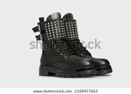 Black women's fashion combat boots isolated on white background. Female classic spring autumn shoes. Leather laced casual footwear with metal rivets, spikes, buckle. Punk, emo, grunge, goth style