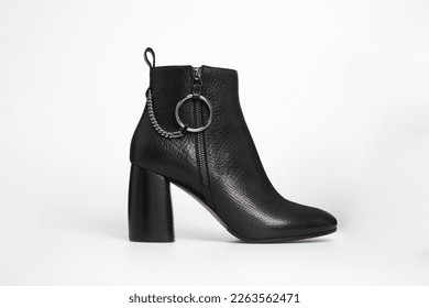 Black women's fashion leather high heel ankle boot isolated on white background. Female classic spring autumn shoe. Blank casual classic footwear with metal ring and chain. Mock up, template