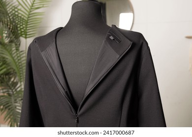 Black women's lace dress with a zipper on the back and a label for the brand name on the reverse side. Clothes on a tailor's mannequin. - Powered by Shutterstock