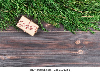 Black wooden christmas background. twigs of thuja. Original, fresh floral design for xmas card. empty space for holiday greetings.
