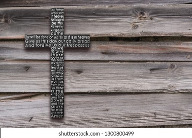 Black wooden cross with the Lord's prayer on the shabby  dark brown wooden  plank background - Shutterstock ID 1300800499