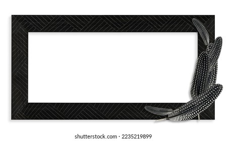 Black wooden frame with carved hatch design and arranged guinea fowl feathers in black and white on the right.