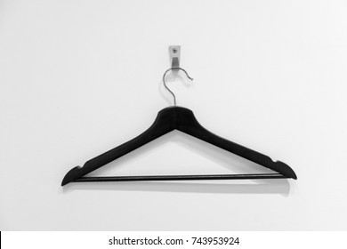 Black wooden hanger for clothes hanging on silver holder against the white background - Powered by Shutterstock