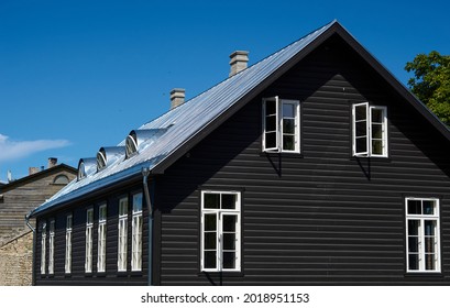 black wooden house under a gray roof against a blue sky. building architecture. High quality photo