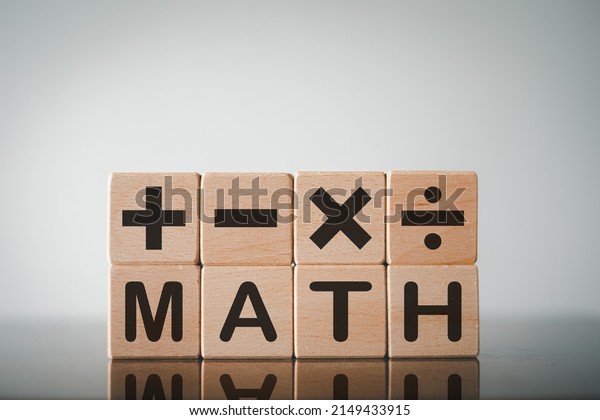 Black Word MATH and mathematical operations\
or Plus, minus, multiply, divide symbols on wooden cube over white\
background.