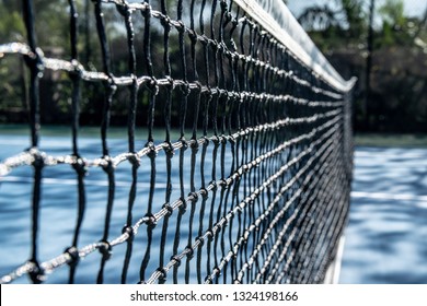 Black Woven Net On Hardcourt Surface Tennis Court In Game/sports Outdoor Park.