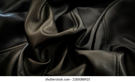 Black Wrinkled Leather Jacket Texture Forming Contrasts Of Light And Shadow