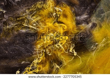 Black yellow abstract ocean background. Splashes and waves of paint under water, clouds of interstellar smoke in motion