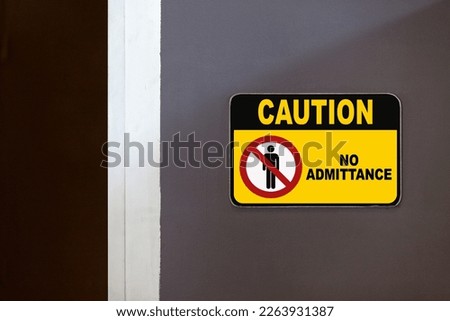 Black and yellow caution sign on the side of an open door stating 