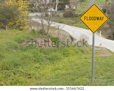 A black and yellow 'floodway' sign depicting a floodway zone