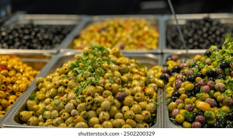 Black, yellow and green olives, marinated in olive oil with herbs and spices, market stalll at the weekly market in Rotterdam. Mediterranean vegetables, healthy food. - Powered by Shutterstock