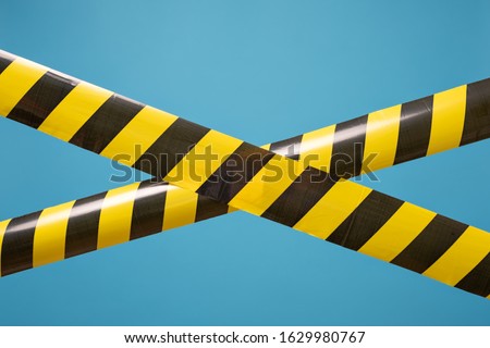 Black and yellow lines of barrier tape forbids passage. Concept of No entry. Protection from coronavirus.
