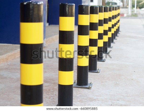 Black yellow pole Placed in a row to prevent the car\
to come in.