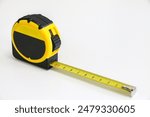 A black and yellow retractable tape measure held in place at 10 cm, measuring length, width and height concept, accuracy and precision