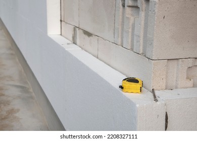 Black Yellow Tape Measure On White Rigid Polyurethane Foam Sheet On Wall. Thermal Insulation.