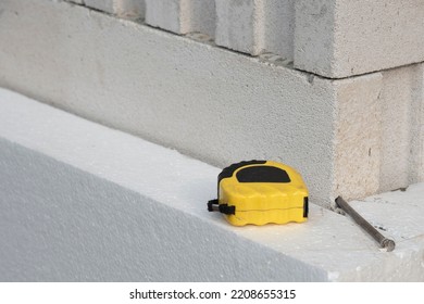 Black Yellow Tape Measure On White Rigid Polyurethane Foam Sheet On Wall. Thermal Insulation.