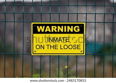Black and Yellow warning sign attached on a fence. The sign stating 