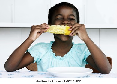 Black Young Girl Eating Corn Cobb