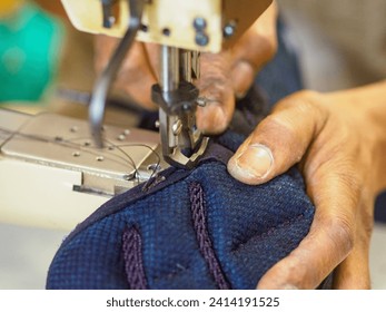 black young man artisan repair shoes with retro vintage industrial sewing machine in messy workshop - Powered by Shutterstock