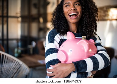 Black Young Woman Hugging Her Pink Piggy Bank