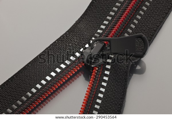 Black\
zipper with red line opened to a gray\
surface