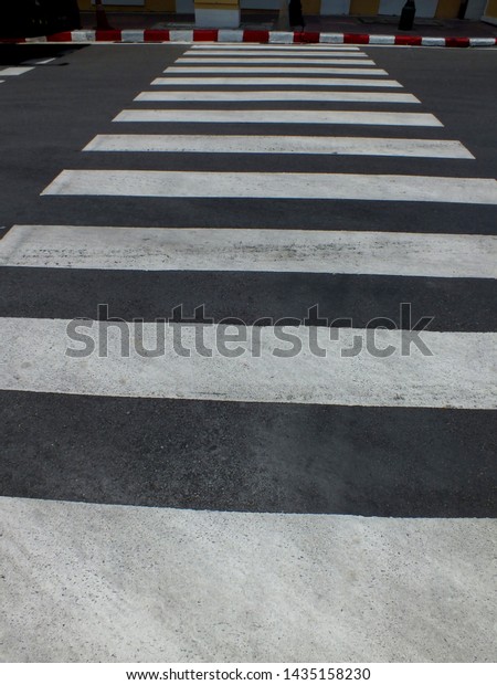Black-and-white crosswalk symbols help reduce\
road accidents.