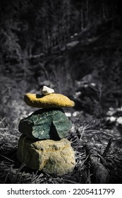 Blackandwhite picture with a little bit of colour. This is a small cairn built in a riverbed.