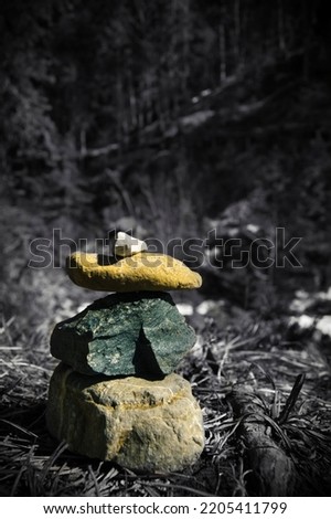 Blackandwhite picture with a little bit of colour. This is a small cairn built in a riverbed.